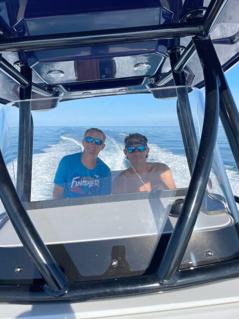 Two men smiling while driving speed boat
